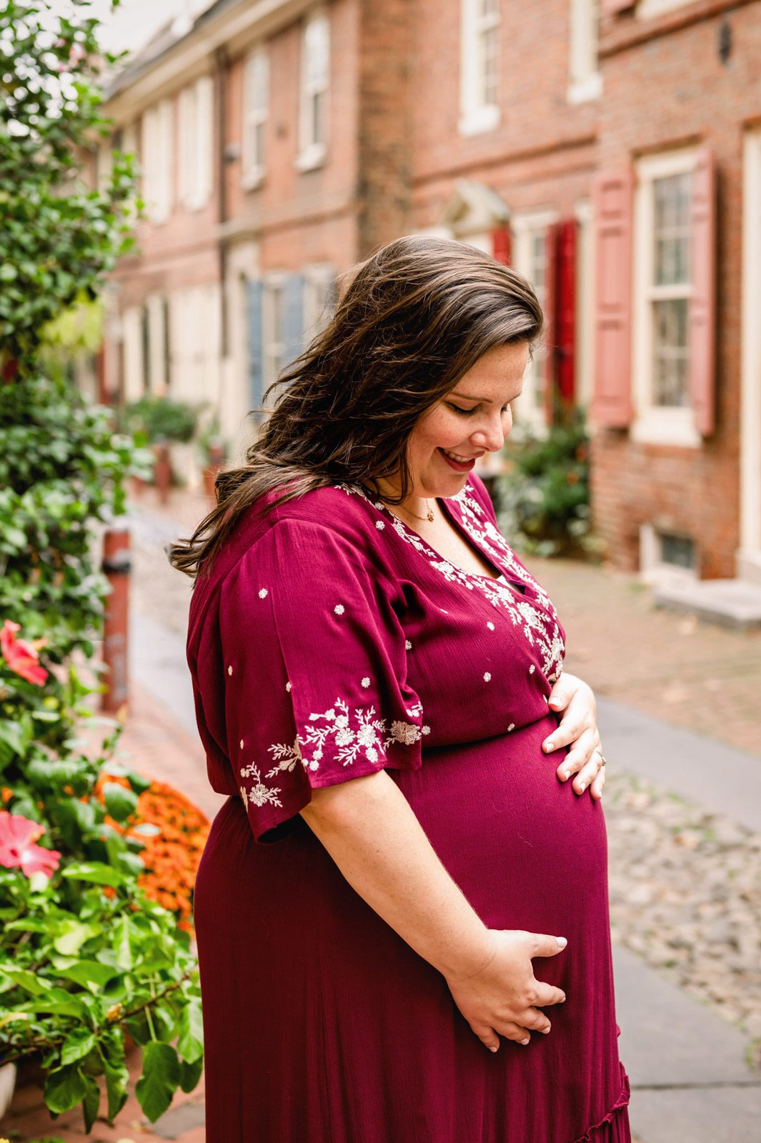 An expecting mother smiling down at her belly during a Philadelphia maternity photo session