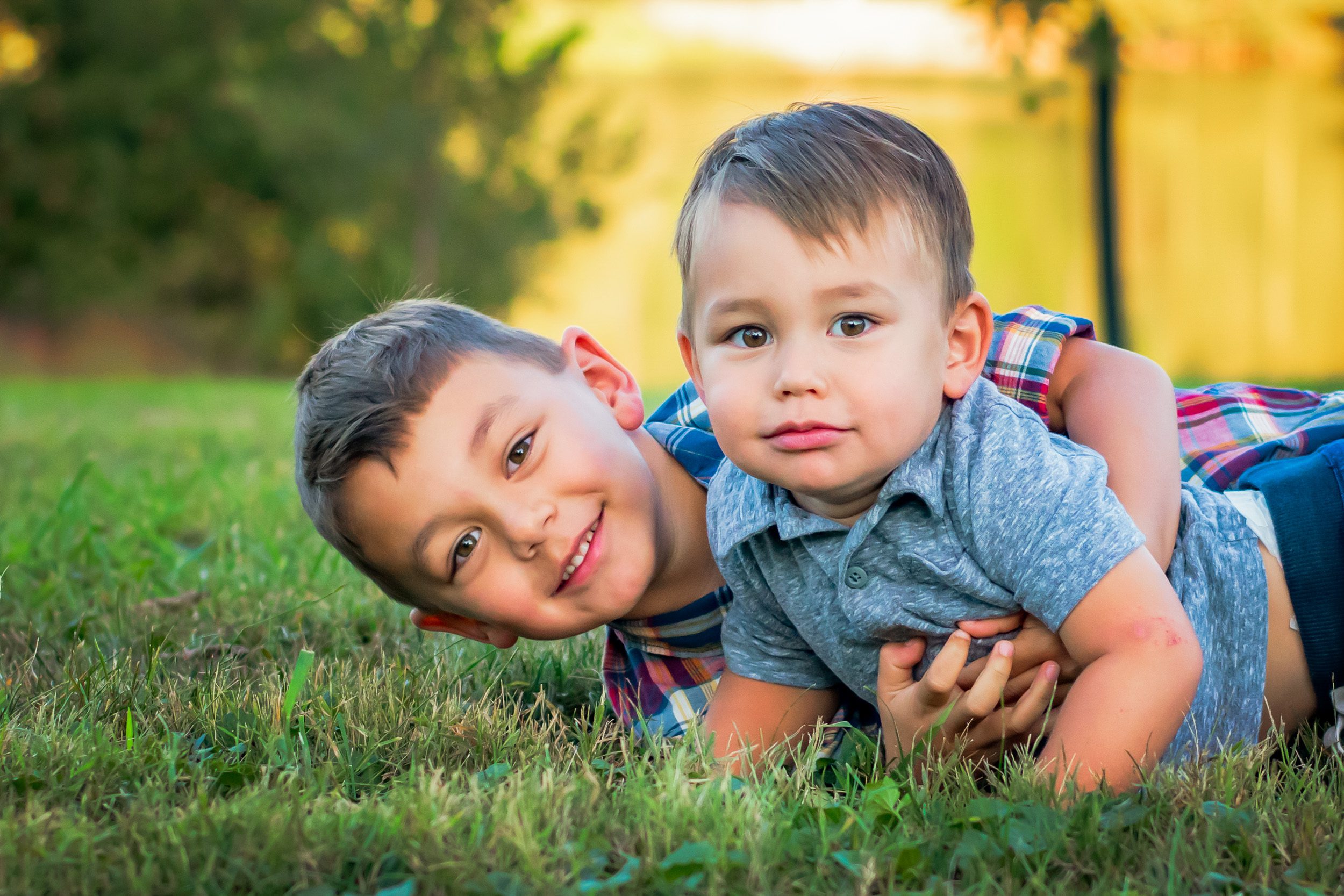 two young brothers hugging in the grass at a family photoshoot