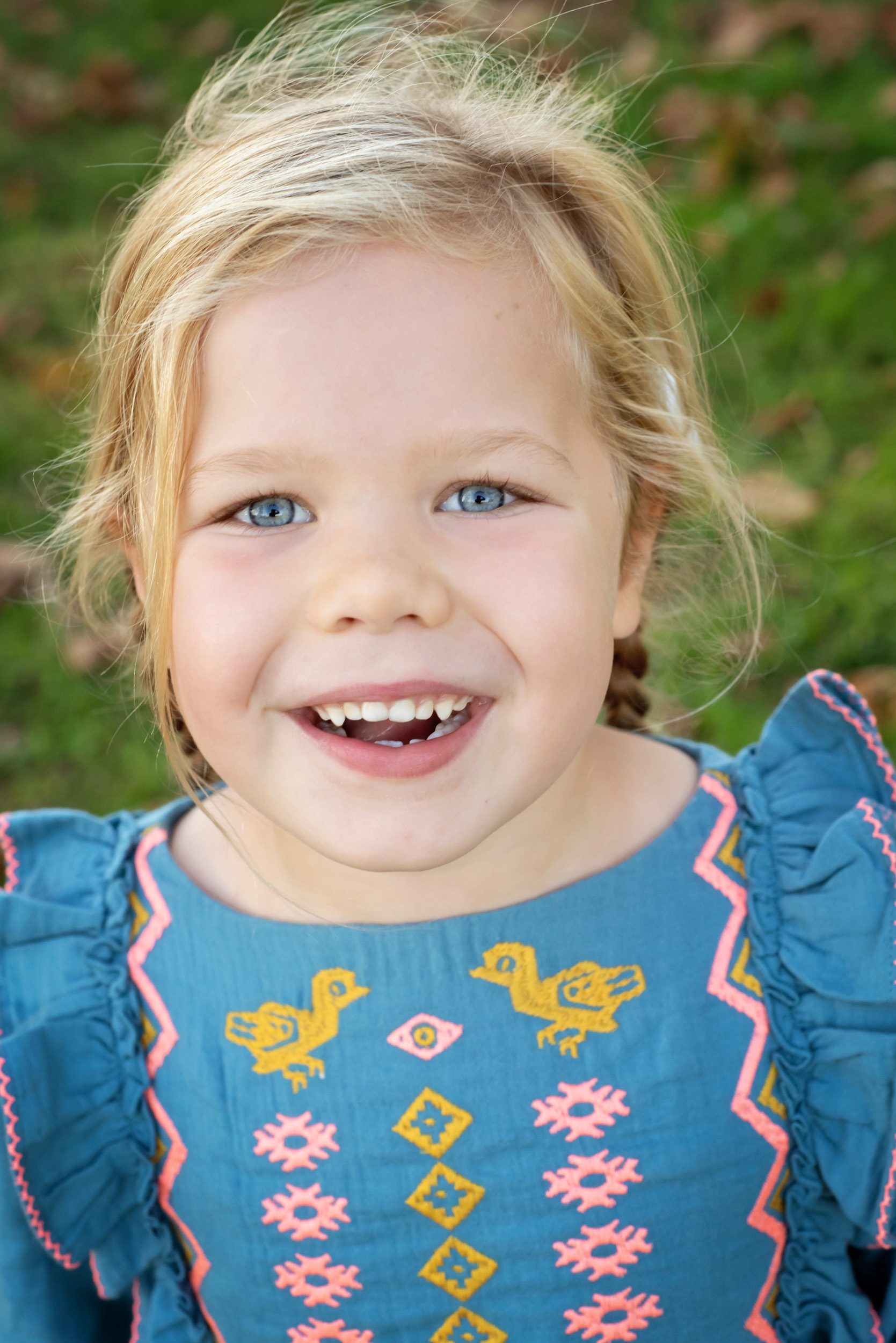 Close up of a young girl looking up at the camera and smiling during a family photoshoot