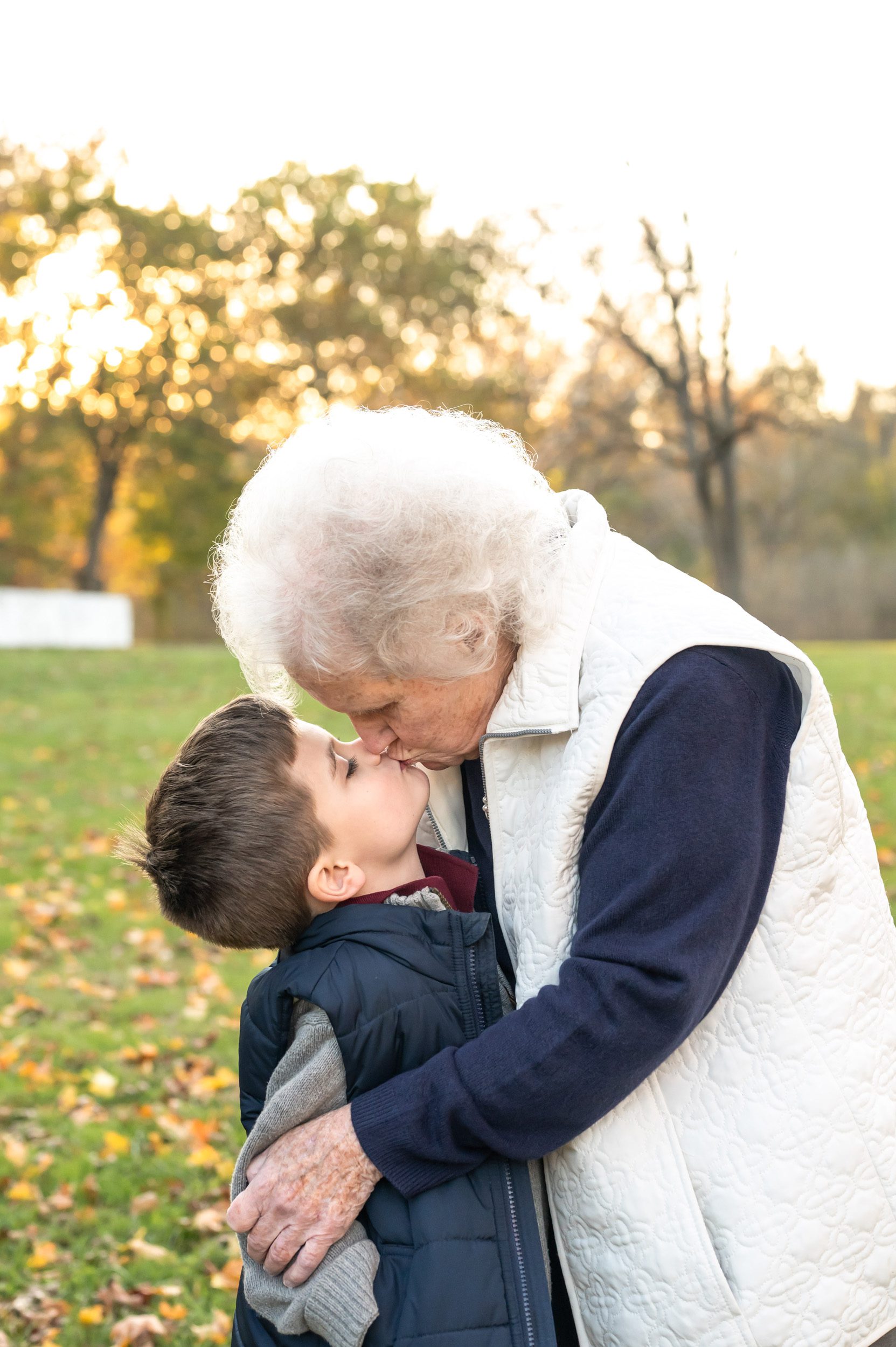 A grandmother hugging and kissing her grandson during an extended family photo session