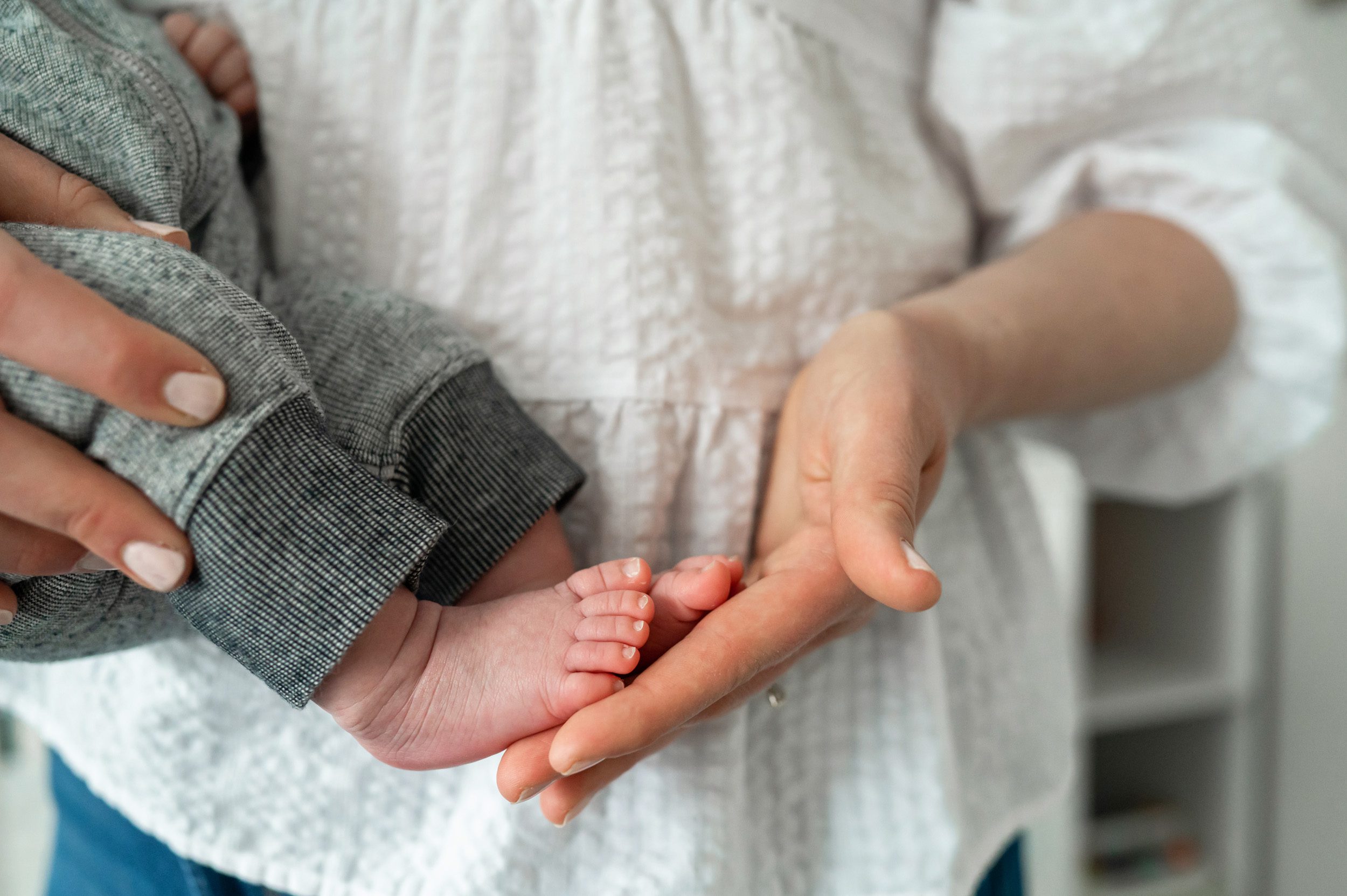 Close up of tiny newborn baby toes in mom's hand during an in home newborn photoshoot