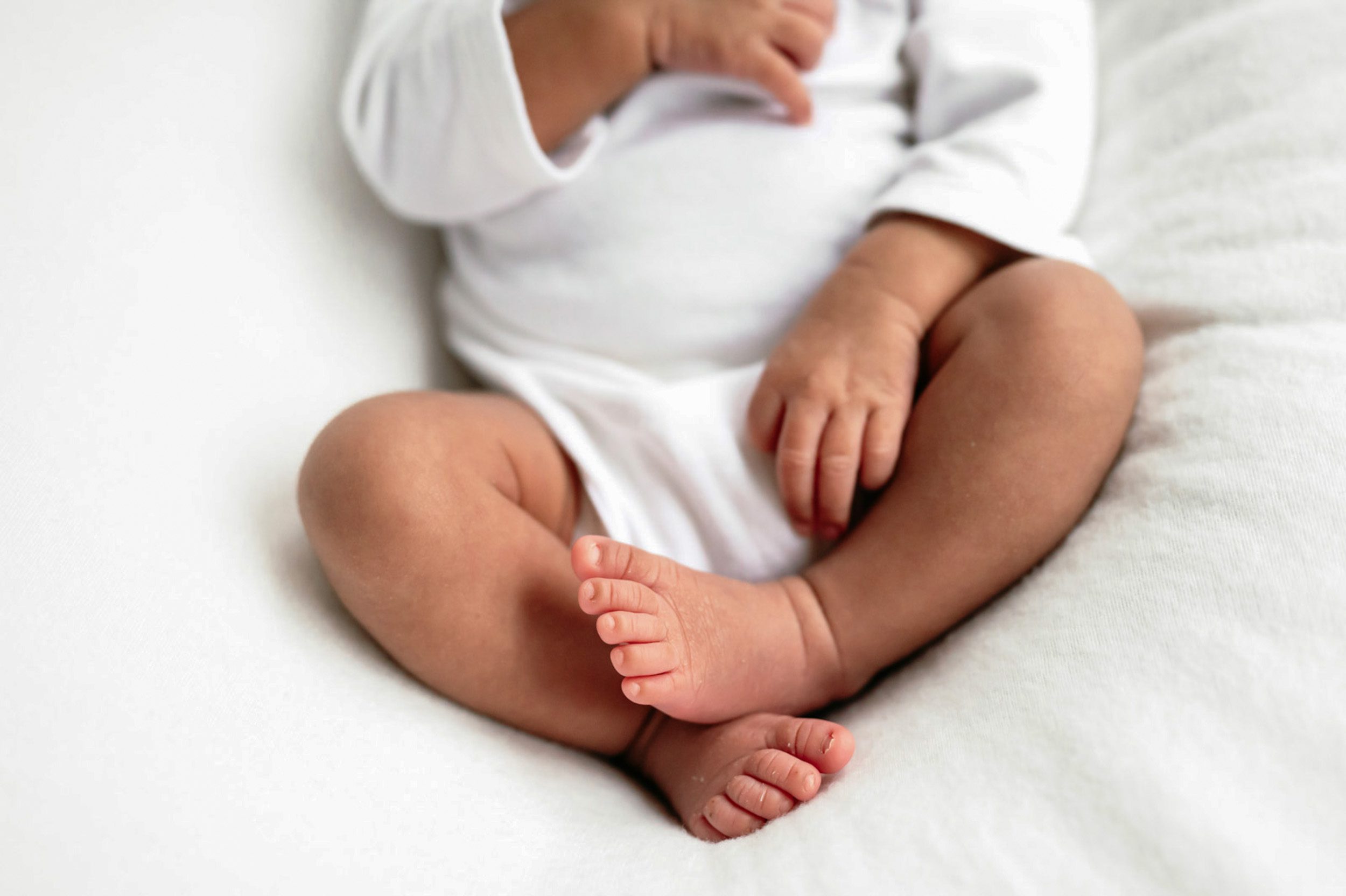 a close up picture of a newborn baby's feet taken on a white backdrop during a newborn photoshoot