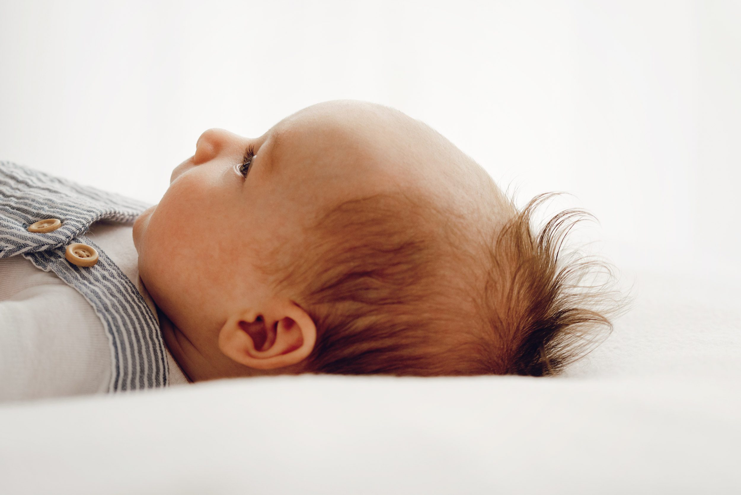 a close up picture of a baby boy's head with a focus on his cute mohawk hair taken during a newborn photography session 