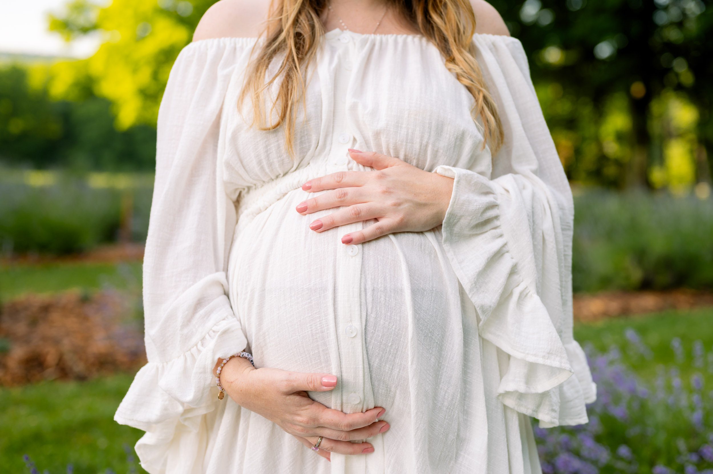 a close up picture of an expecting mother cradling her belly with her hands during a maternity photo session