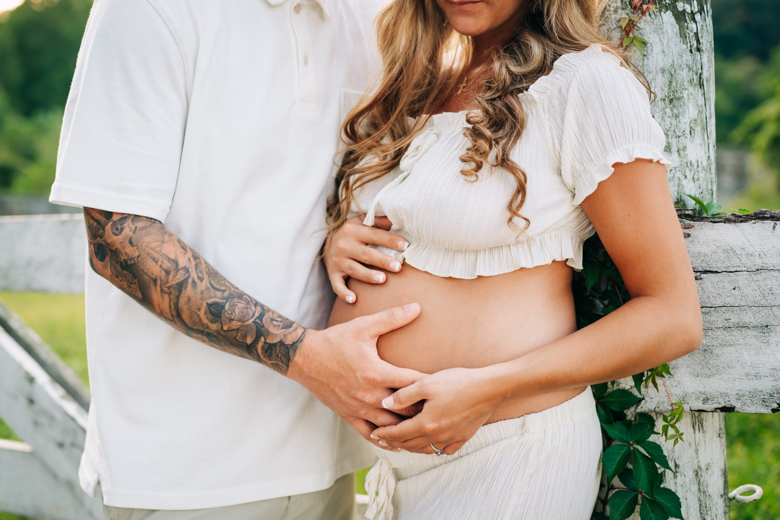 a close of up picture of a pregnant mom's belly as she and her husband both touch her belly during a Valley Forge maternity photoshoot